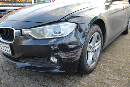 Foto eines beschädigten BMWs bei dem ein gutachten zur schadensaufnahme erstellt wird